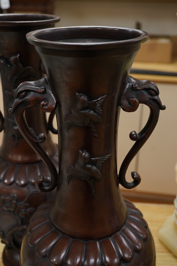 A large pair of Japanese bronze vases, early 20th century, decorated in relief with birds and flowers, 45cm high